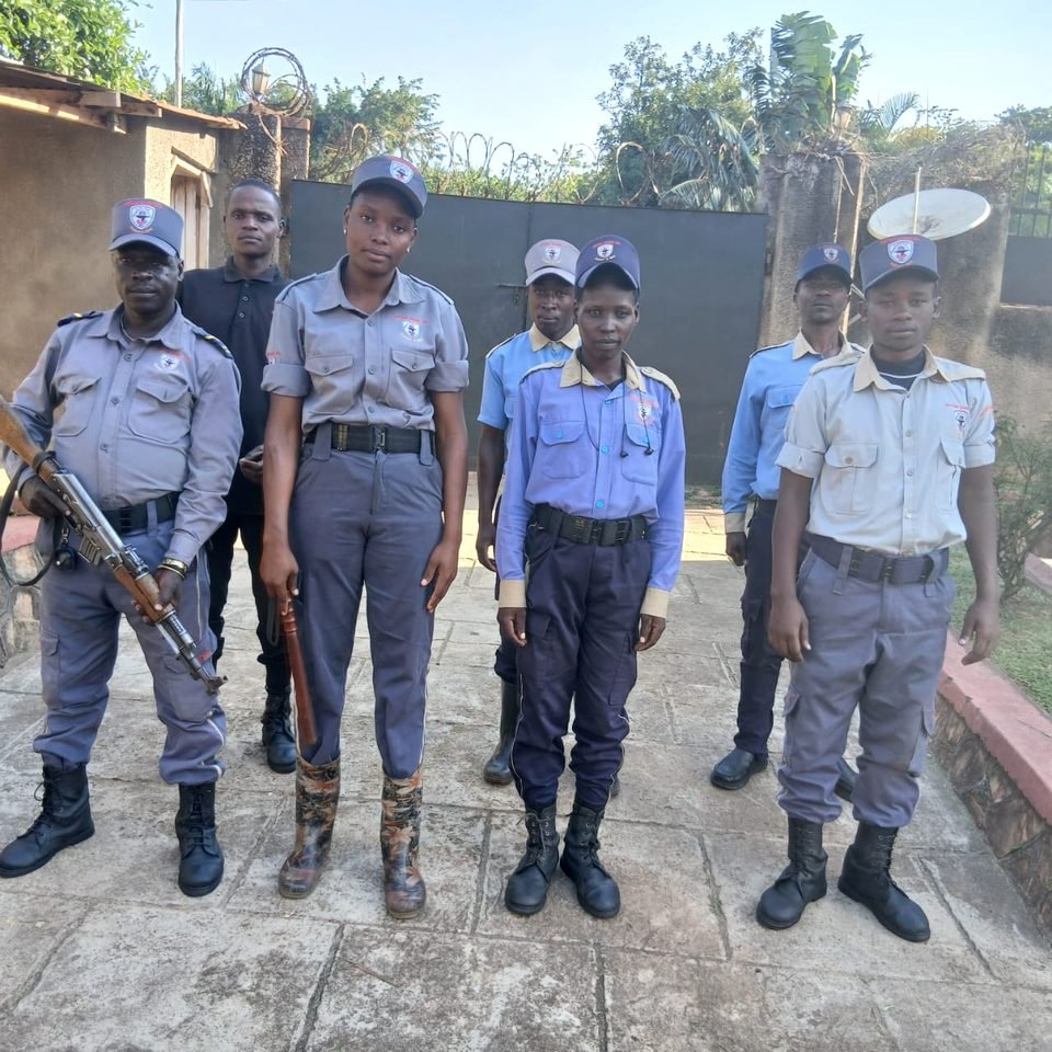 Neptune officers in mixed uniforms lined up in front of a gate